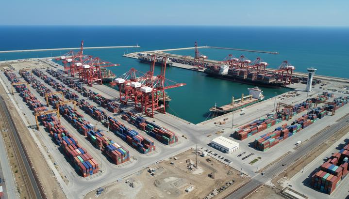 Грузовой порт Мисурата в Ливии с высоты птичьего полета: контейнерные краны, штабели контейнеров и пришвартованные суда.